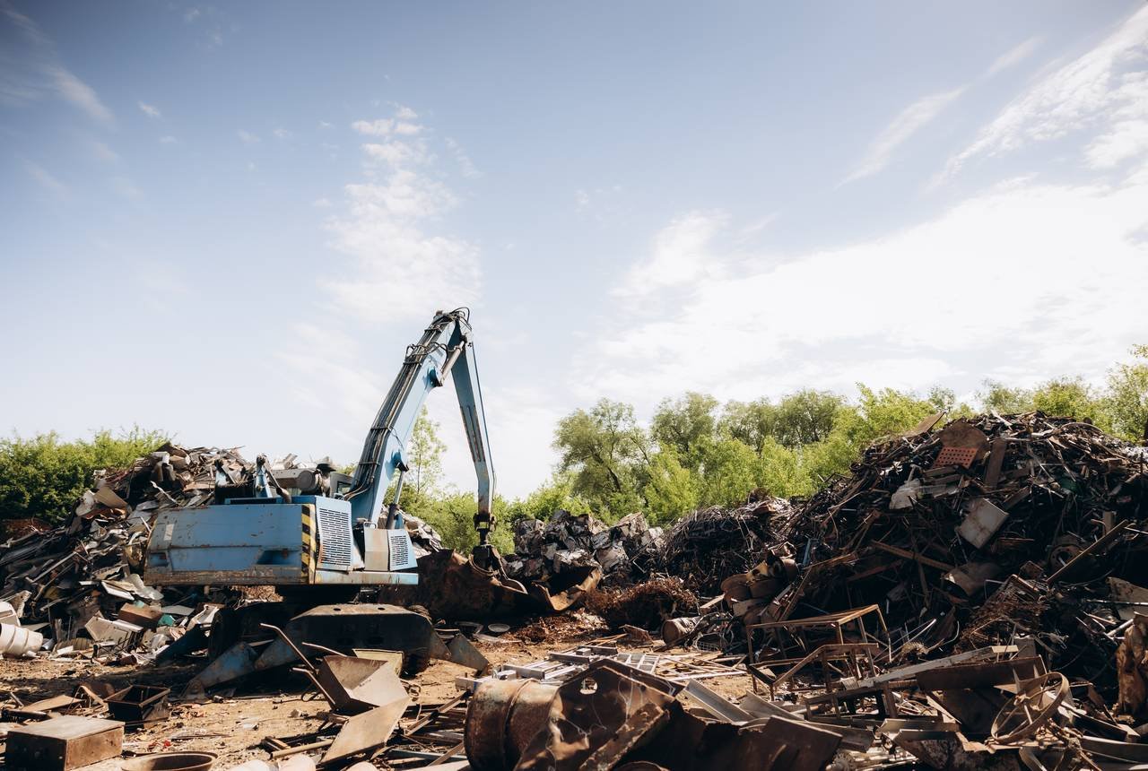 Excavator working a large scrap pile at the Almetco yard